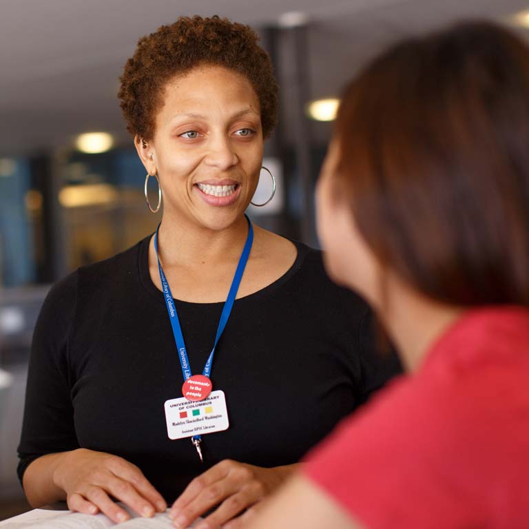 A staff member talks with a student.